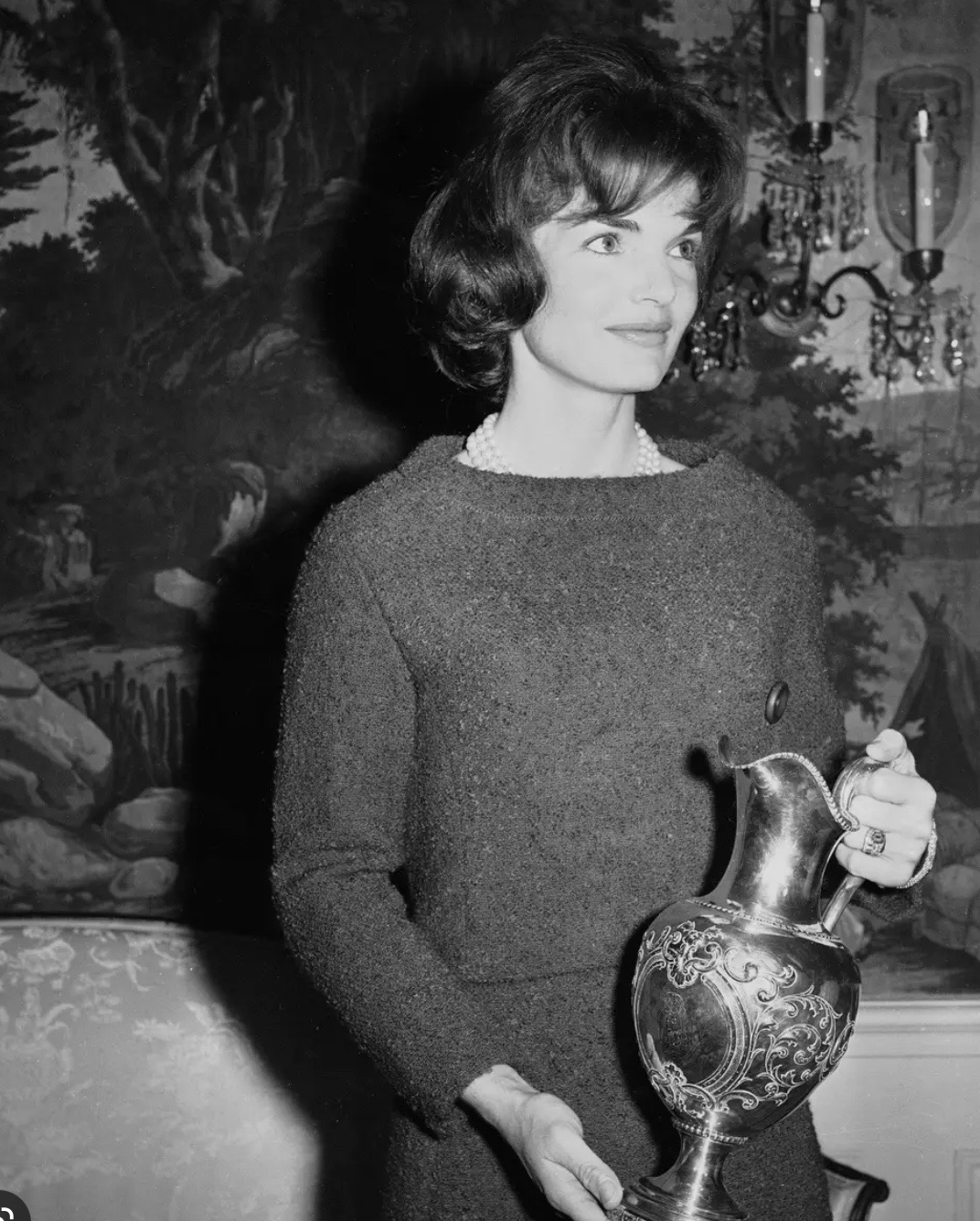 Jacqueline Kennedy holds a vase at the White House.
